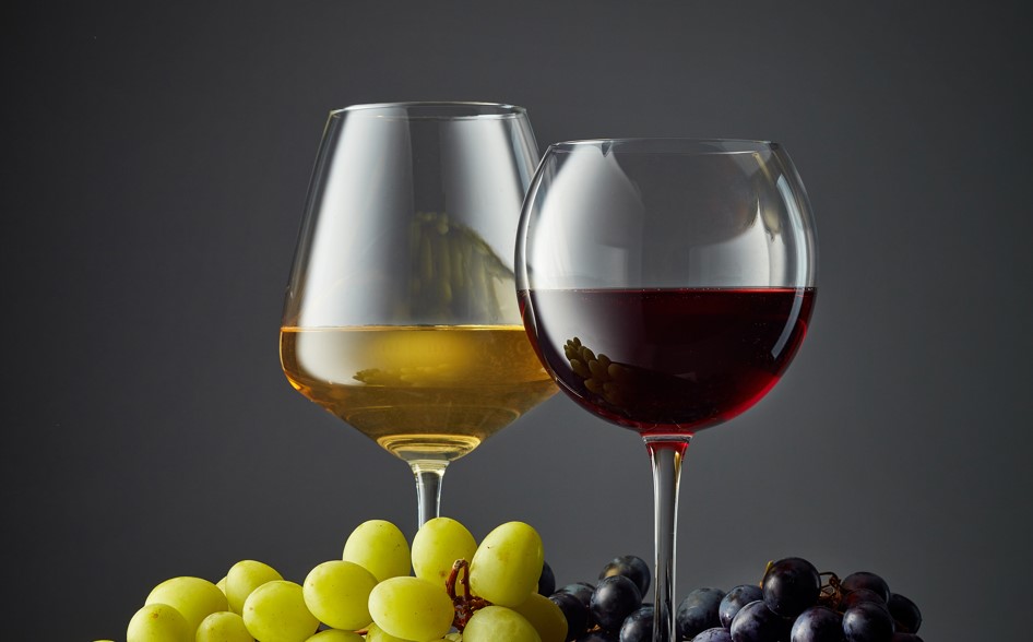 zwei gefüllte Gläser mit Weißwein und Rotwein